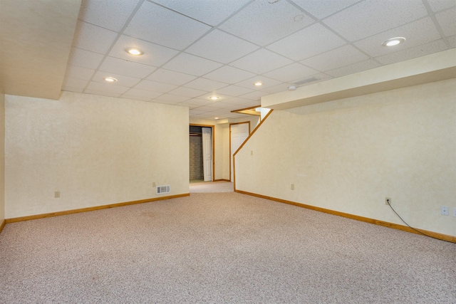 basement with a drop ceiling and carpet