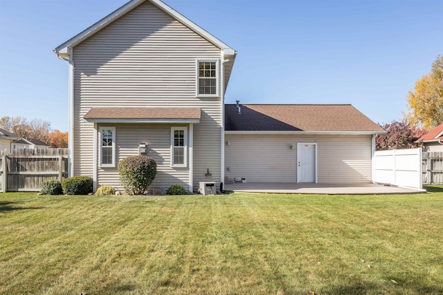 rear view of property featuring a yard and a patio