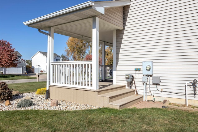 entrance to property featuring a lawn and a porch