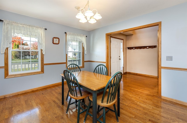 dining area with light hardwood / wood-style floors, a chandelier, and a wealth of natural light