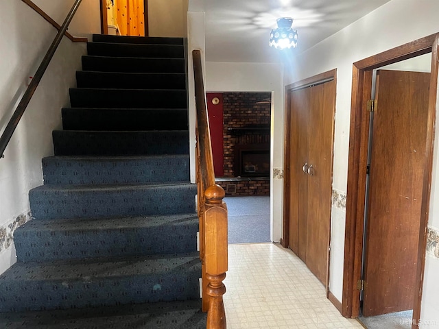 stairs featuring carpet floors and a fireplace