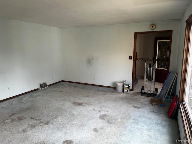 carpeted spare room featuring a baseboard heating unit