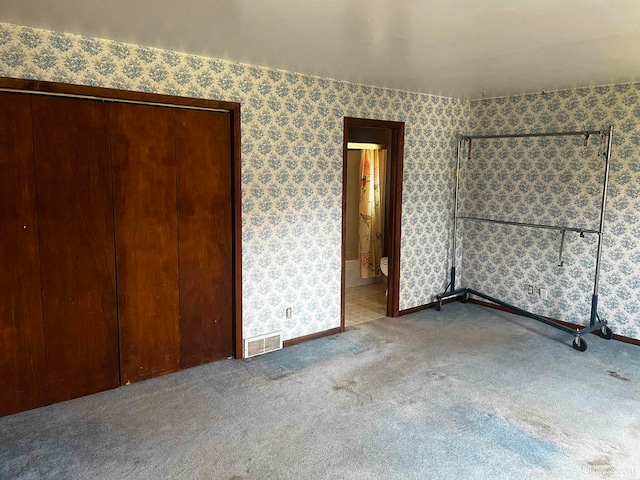 unfurnished bedroom featuring a closet and carpet flooring