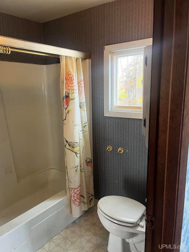 bathroom featuring shower / tub combo with curtain and toilet