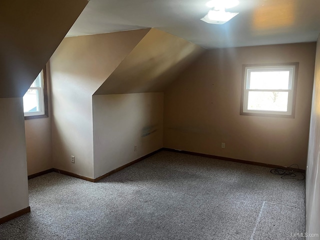 additional living space with carpet flooring, lofted ceiling, and plenty of natural light