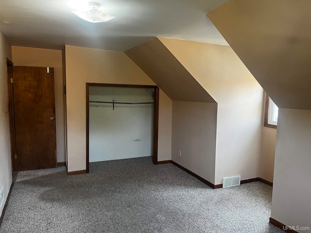 additional living space with vaulted ceiling and carpet flooring