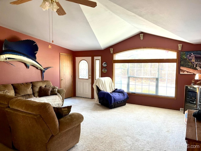 living room with ceiling fan, vaulted ceiling, carpet floors, and plenty of natural light