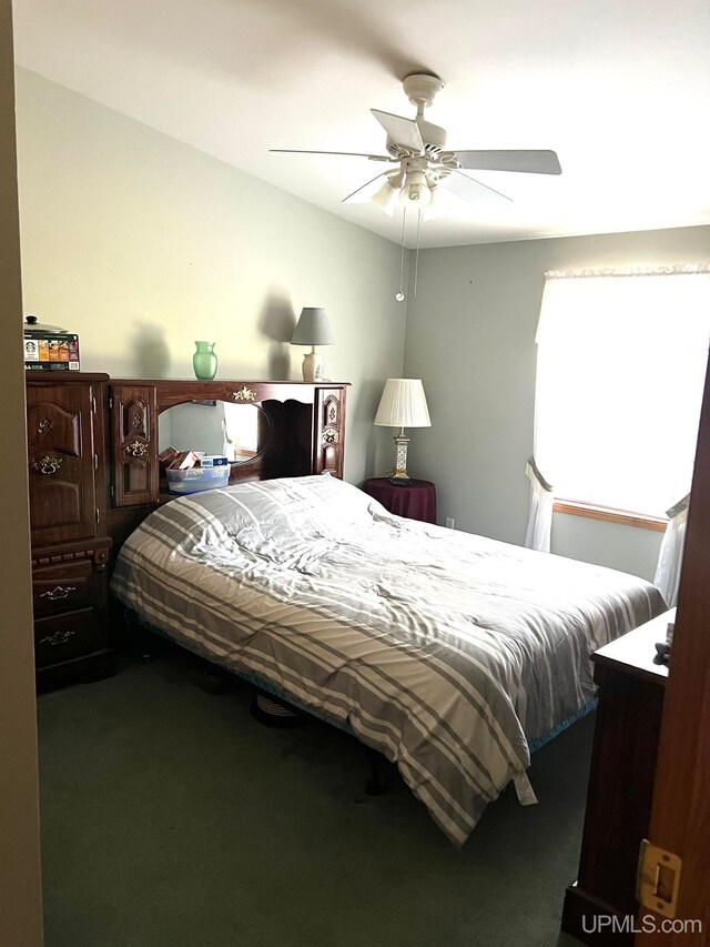 bedroom featuring dark carpet and ceiling fan