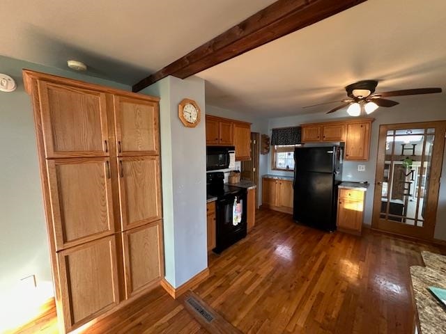 kitchen with a healthy amount of sunlight, black appliances, and dark hardwood / wood-style floors