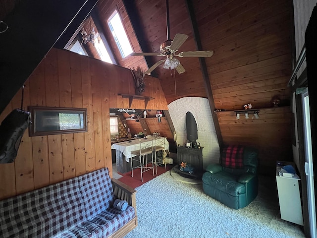 interior space with lofted ceiling with skylight, ceiling fan, and wood walls