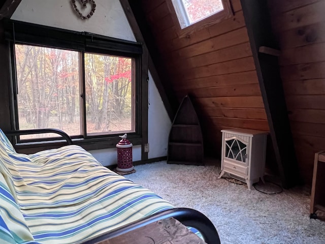 interior space with wood walls, plenty of natural light, light carpet, and vaulted ceiling