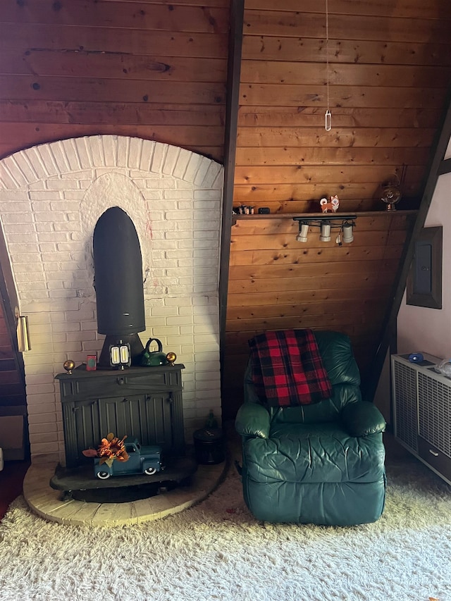 sitting room featuring wooden walls, carpet floors, and electric panel