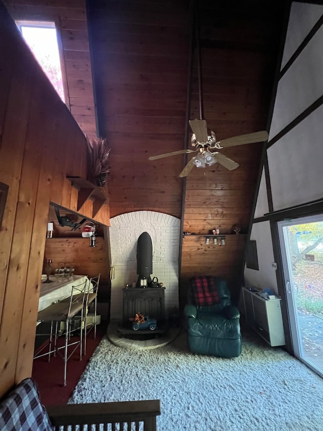 interior space with wooden walls, ceiling fan, and a high ceiling