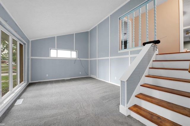 interior space featuring carpet, plenty of natural light, and vaulted ceiling