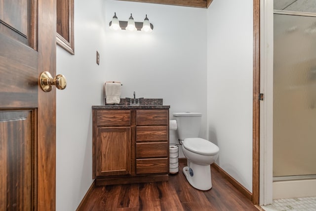 bathroom featuring vanity, toilet, hardwood / wood-style flooring, and an enclosed shower