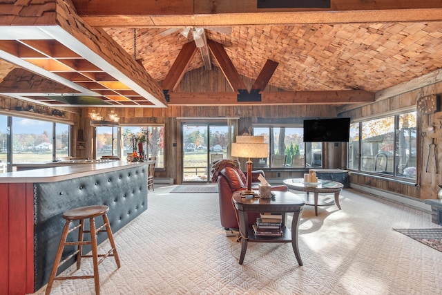 living room featuring wood walls, light colored carpet, and a wealth of natural light