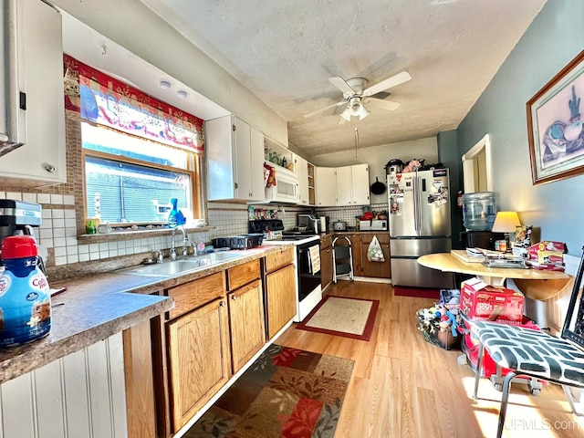 kitchen featuring light hardwood / wood-style flooring, tasteful backsplash, white cabinets, white appliances, and ceiling fan