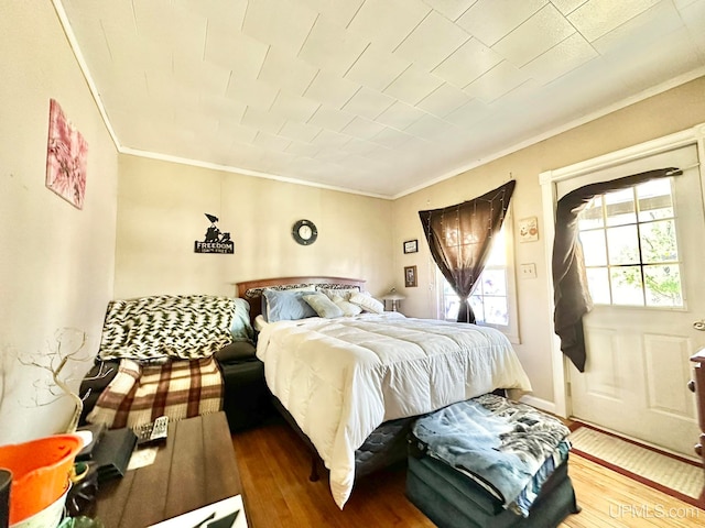 bedroom with crown molding and hardwood / wood-style flooring