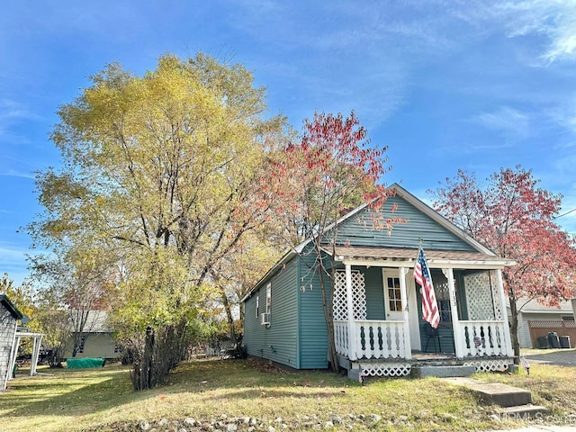 bungalow-style home featuring a front lawn and covered porch