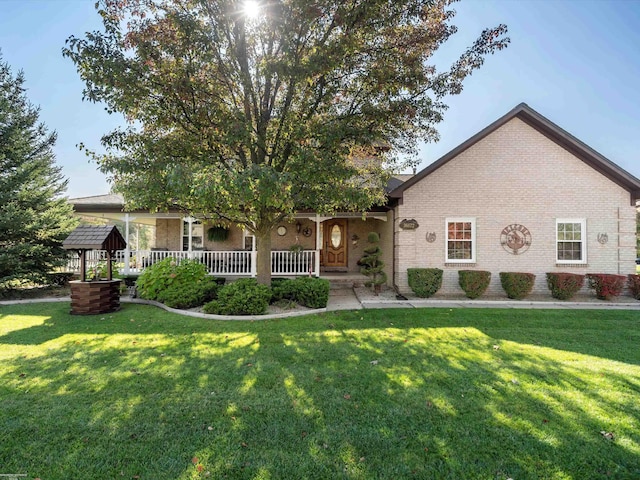 view of front of home featuring covered porch, a front lawn, and brick siding