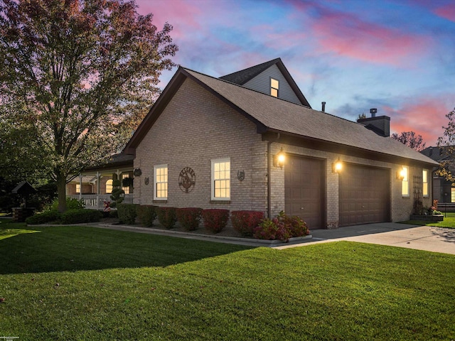view of side of property with a garage, concrete driveway, a lawn, and brick siding