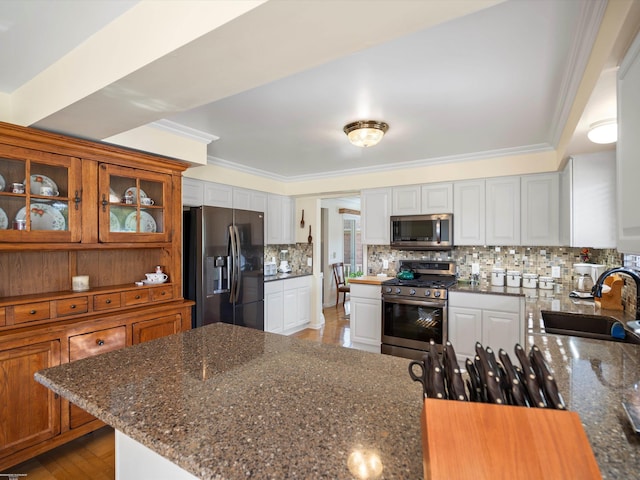 kitchen with crown molding, white cabinets, stainless steel appliances, and sink