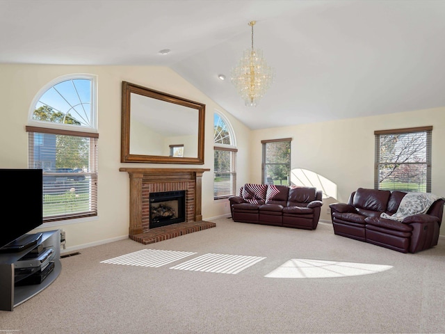 carpeted living room with an inviting chandelier, a fireplace, vaulted ceiling, and a wealth of natural light