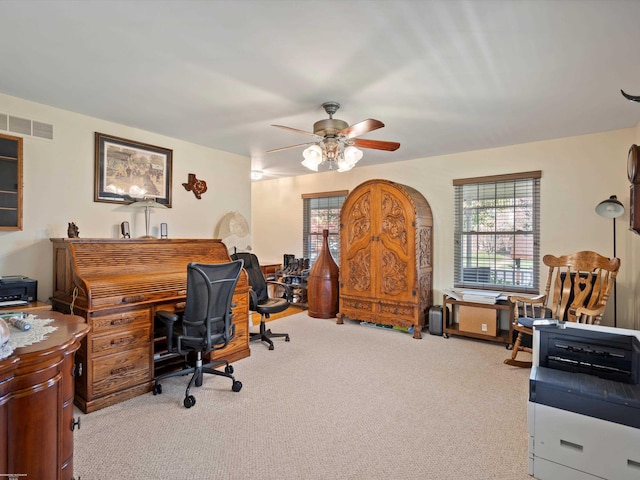 carpeted office space featuring ceiling fan