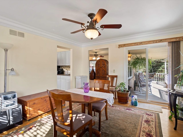 dining area featuring crown molding, light wood-type flooring, and ceiling fan