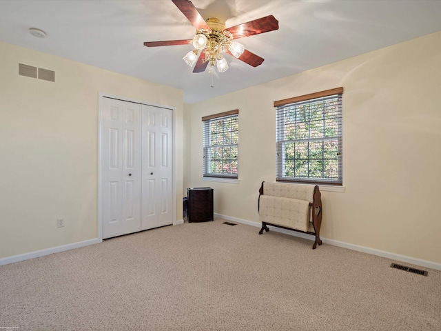 unfurnished bedroom featuring carpet floors, a closet, and ceiling fan