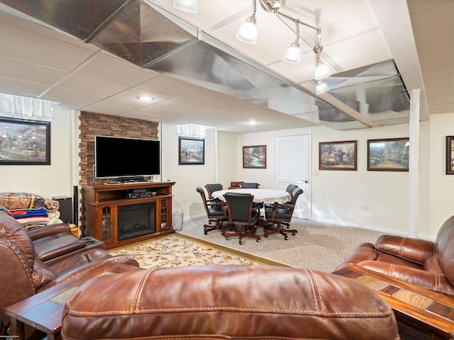 carpeted living room featuring a stone fireplace