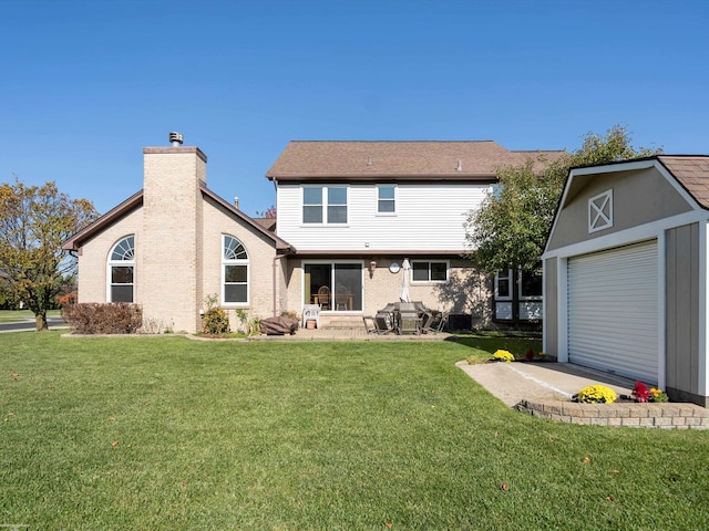 back of property featuring a patio, a lawn, and a garage