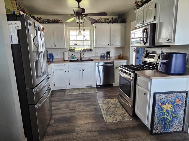 kitchen featuring appliances with stainless steel finishes, white cabinets, and sink