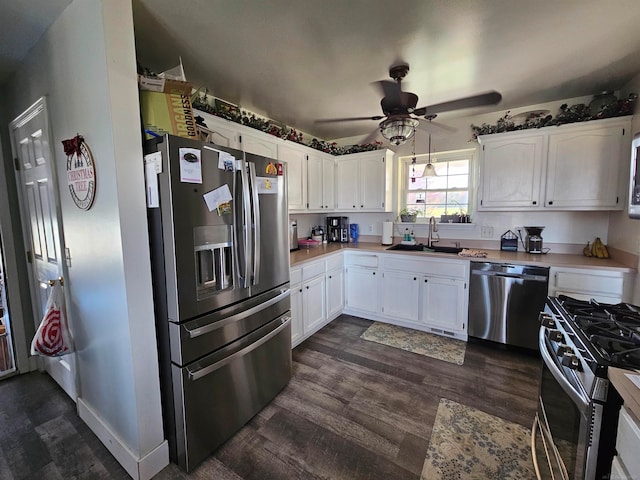 kitchen featuring dark wood-type flooring, stainless steel appliances, sink, white cabinets, and ceiling fan