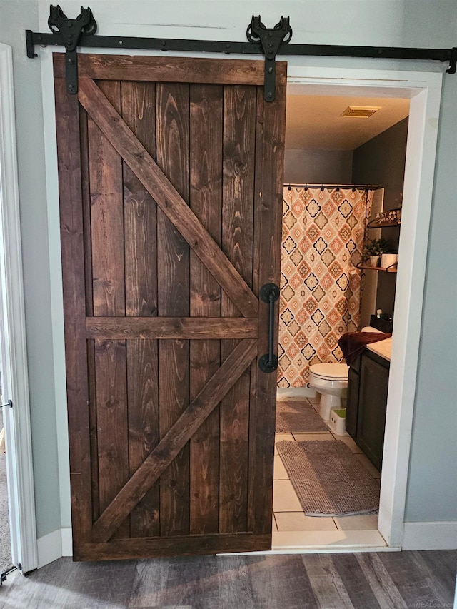 bathroom featuring vanity, hardwood / wood-style flooring, toilet, and walk in shower