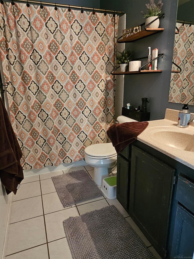 bathroom with vanity, walk in shower, toilet, and tile patterned flooring