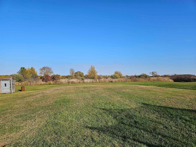 view of yard with a storage unit and a rural view