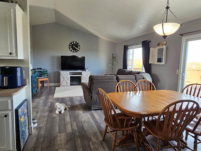 dining room with dark hardwood / wood-style flooring and vaulted ceiling