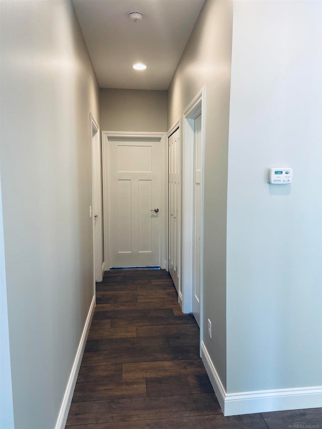 corridor with dark hardwood / wood-style flooring