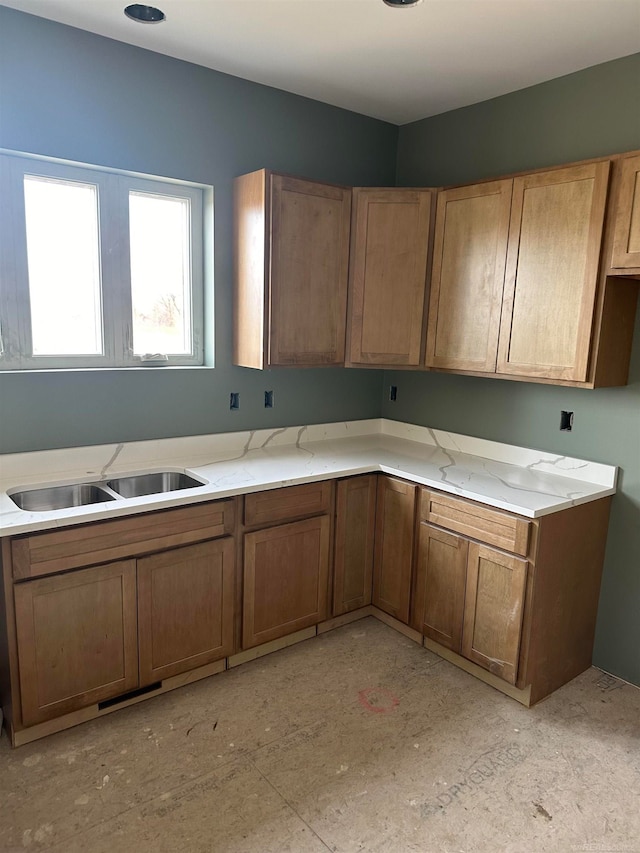 kitchen featuring light stone countertops and sink