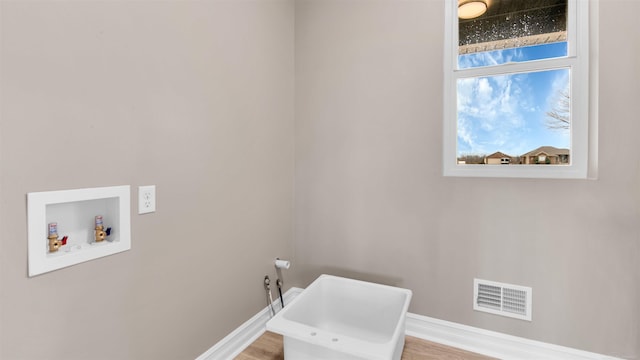 clothes washing area with hookup for a washing machine and light wood-type flooring