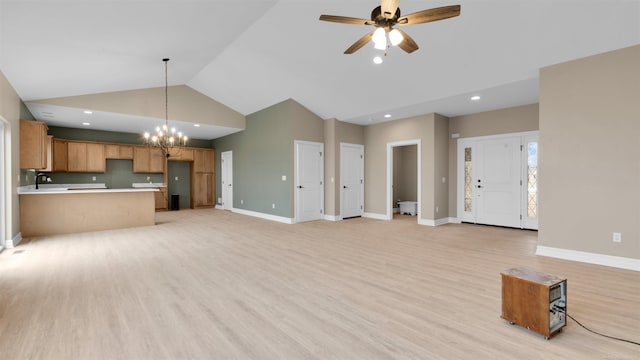 unfurnished living room featuring ceiling fan with notable chandelier, sink, high vaulted ceiling, and light hardwood / wood-style flooring