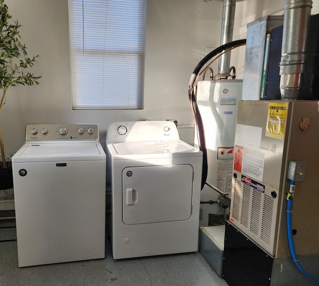 clothes washing area featuring heating unit, separate washer and dryer, and gas water heater