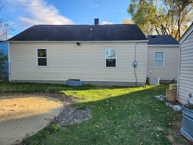 rear view of house with a yard and central air condition unit