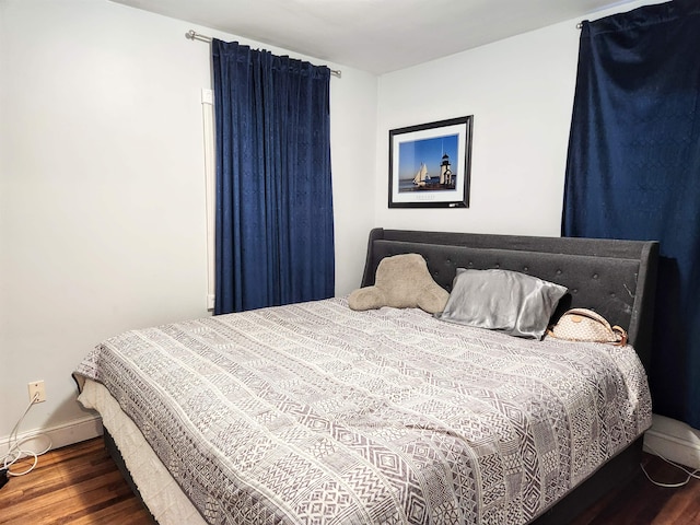 bedroom with dark hardwood / wood-style floors