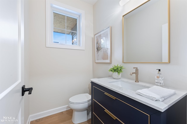 bathroom featuring toilet, hardwood / wood-style floors, and vanity