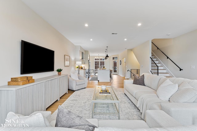 living room featuring light hardwood / wood-style flooring and an inviting chandelier