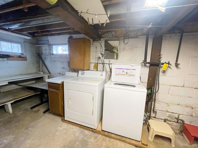 laundry area with washer and clothes dryer and cabinets