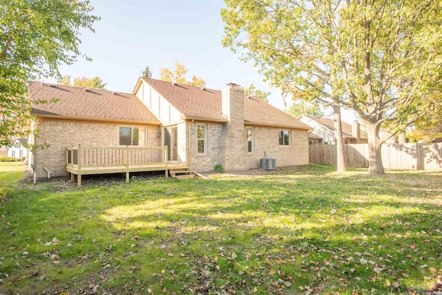 rear view of house with cooling unit, a wooden deck, and a lawn