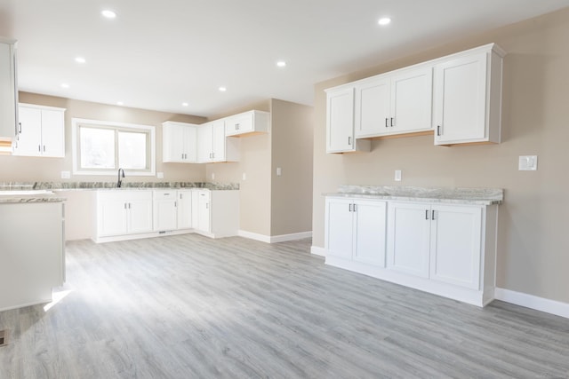 kitchen featuring light hardwood / wood-style floors, white cabinets, and sink